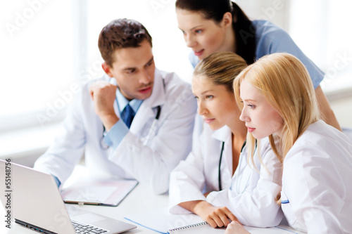 Photo: group of doctors looking at tablet pc group of doctors looking at tablet pc