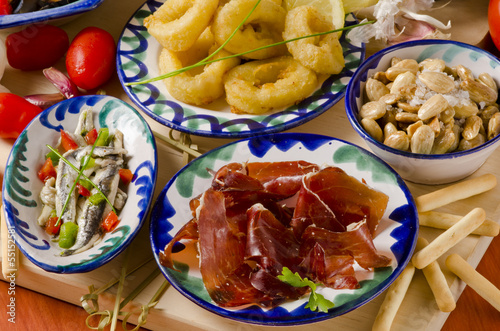 Photo: Spanish Cuisine. Assorted tapas on ceramic plates. Spanish Cuisine. Assorted tapas on ceramic plates.