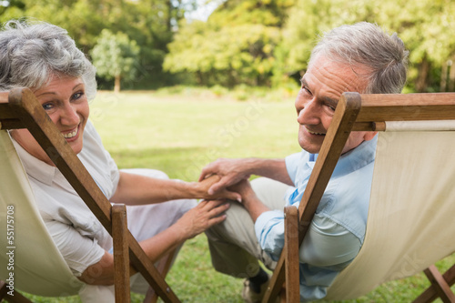 Photo: Happy mature couple smiling at camera Happy mature couple smiling at camera