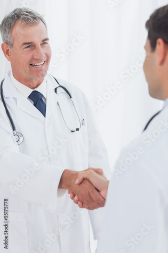 Photo: Experienced doctor welcoming his new coworker Experienced doctor welcoming his new coworker