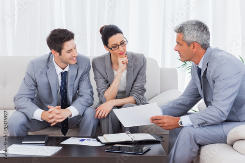 Photo: Business people working and talking together on sofa Business people working and talking together on sofa