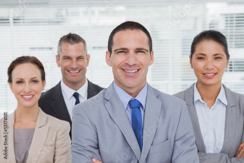 Photo: Smiling coworkers posing crossing arms Smiling coworkers posing crossing arms