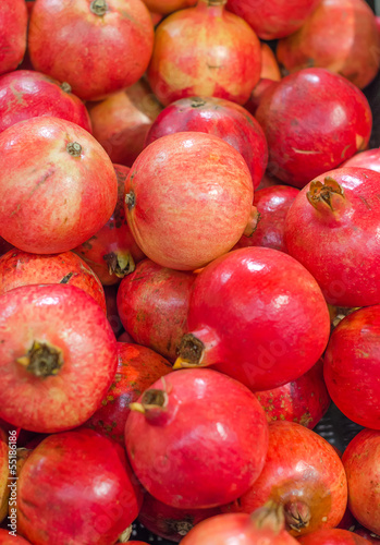 Photo: Lot of red fresh pomegranates closeup view Lot of red fresh pomegranates closeup view