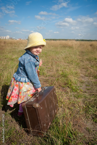 Photo: lonely girl with suitcase. Back view lonely girl with suitcase. Back view