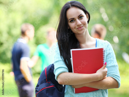 Photo: Outdoors portrait of a beautiful tanned teen student girl. Outdoors portrait of a beautiful tanned teen student girl.