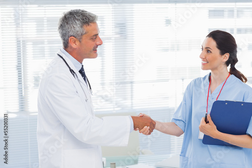 Photo: Smiling doctor shaking hands with nurse Smiling doctor shaking hands with nurse