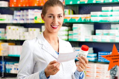 Photo: Female pharmacist in pharmacy with medicament Female pharmacist in pharmacy with medicament