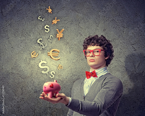 Photo: Young businessman holding moneybox Young businessman holding moneybox