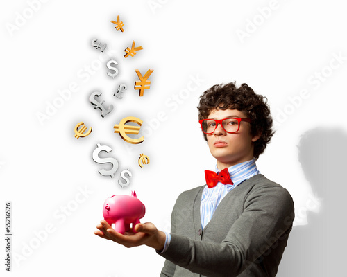 Photo: Young businessman holding moneybox Young businessman holding moneybox