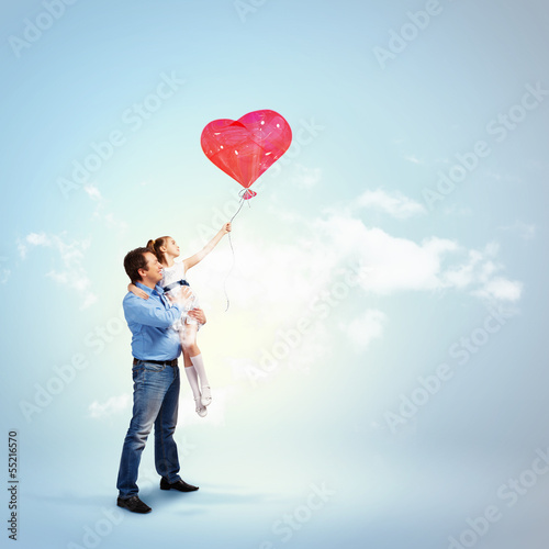 Photo: Father holding his daughter and a red heart Father holding his daughter and a red heart