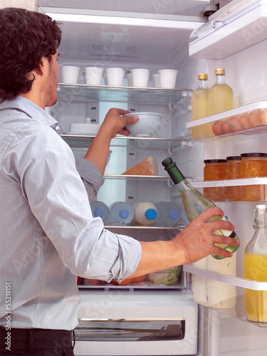 Photo: Man standing near freezer l Man standing near freezer l