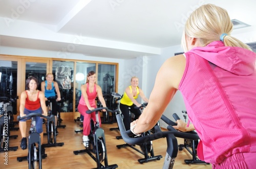 Photo: Beautiful women doing exercise in a spinning class at gym Beautiful women doing exercise in a spinning class at gym