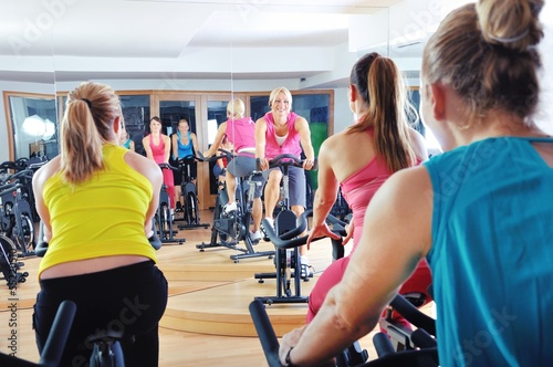 Photo: Beautiful women doing exercise in a spinning class at gym Beautiful women doing exercise in a spinning class at gym