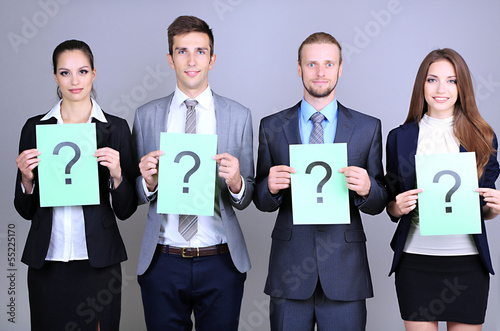 Photo: Business team standing in row with question mark Business team standing in row with question mark