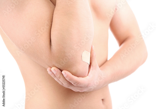 Photo: Young man with adhesive bandage on hand, isolated on white Young man with adhesive bandage on hand, isolated on white