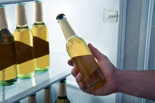 Photo: Man taking beer from a fridge Man taking beer from a fridge