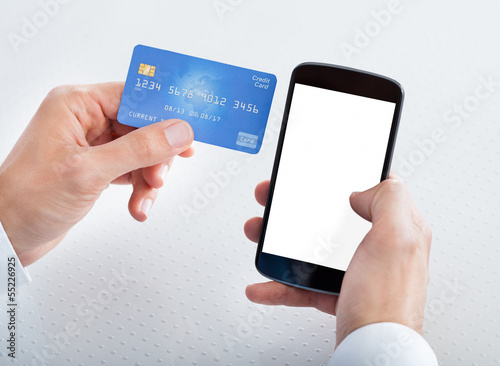 Photo: Man Holding Credit Card And Cell Phone Man Holding Credit Card And Cell Phone