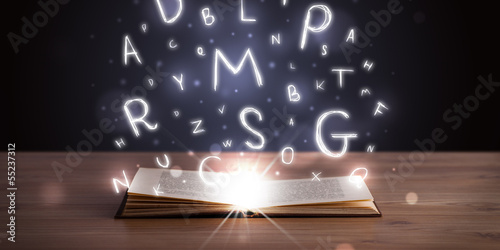 Photo: Open book with glowing letters flying out Open book with glowing letters flying out