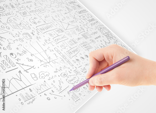 Photo: Human hand sketching ideas on a white paper Human hand sketching ideas on a white paper