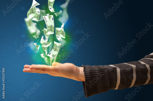 Photo: Glowing money in the hand of a woman Glowing money in the hand of a woman