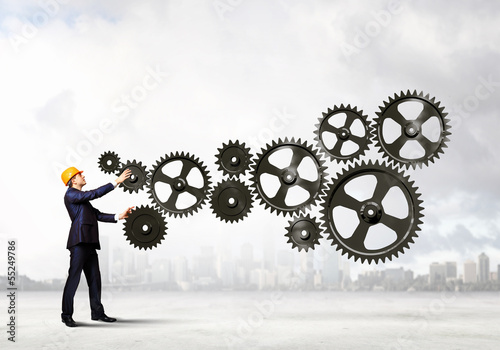 Photo: Businessman and mechanism elements Businessman and mechanism elements