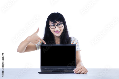 Photo: Female college student pointing at copyspace Female college student pointing at copyspace