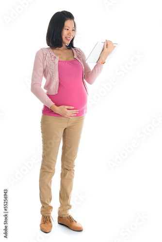Photo: Pregnant Asian woman using computer tablet Pregnant Asian woman using computer tablet