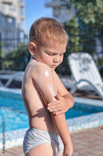 Photo: Little boy applying sunscreen Little boy applying sunscreen
