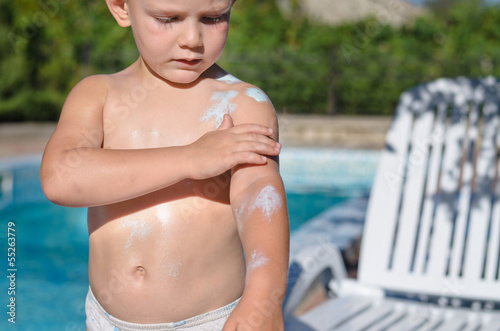 Photo: Young boy applying sunscreen Young boy applying sunscreen