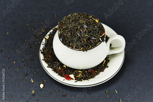 Photo: Tea cup on a dish and tea leaves Tea cup on a dish and tea leaves