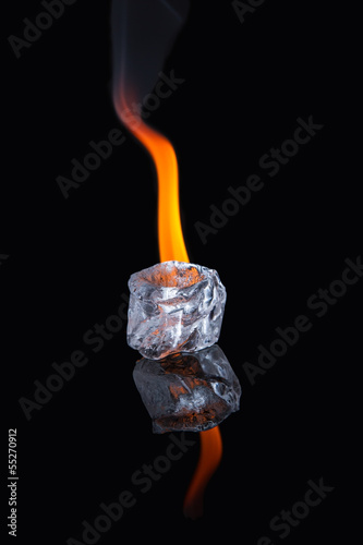 Photo: Ice cube with flame on shiny black surface Ice cube with flame on shiny black surface
