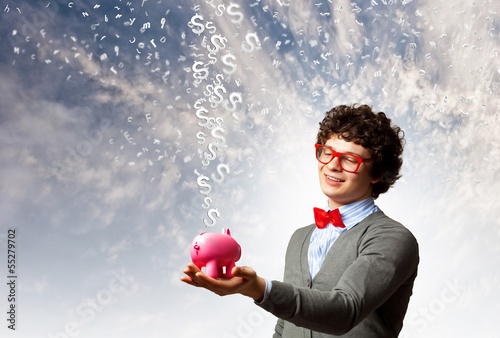 Photo: Young businessman holding moneybox Young businessman holding moneybox