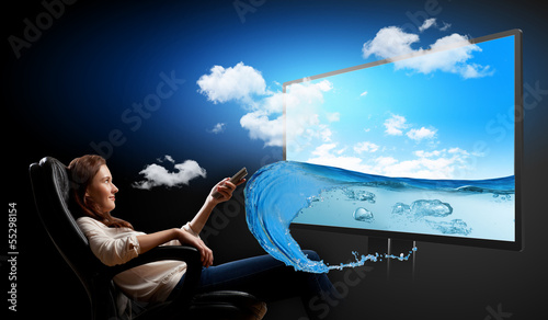 Photo: Young woman watching 3d tv Young woman watching 3d tv