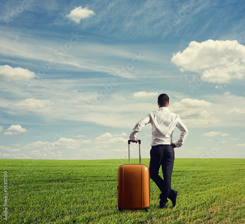 Photo: man with bag standing on the green field man with bag standing on the green field