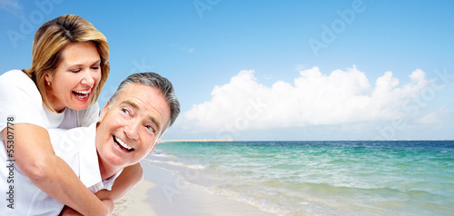 Photo: Happy senior couple on a tropical beach. Happy senior couple on a tropical beach.