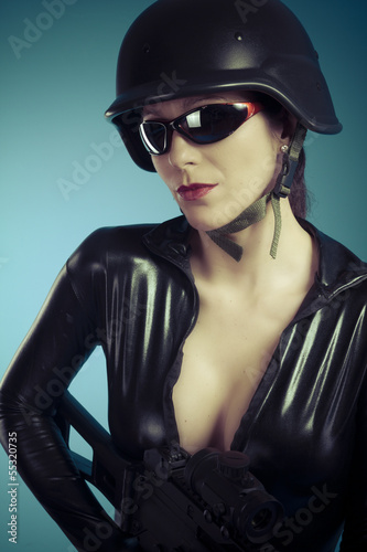 Photo: Police woman holding a big gun, latex costume Police woman holding a big gun, latex costume