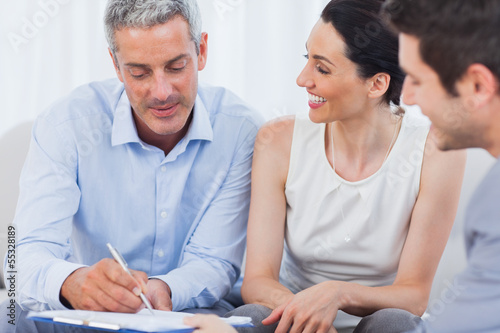 Photo: Client signing a contract with wife Client signing a contract with wife
