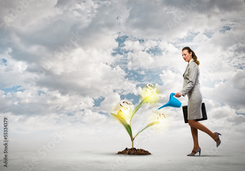 Photo: Business woman watering monet tree Business woman watering monet tree
