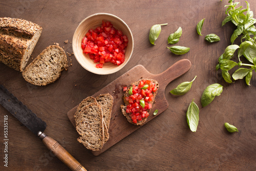 Photo: Making bruschetta on wooden table Making bruschetta on wooden table