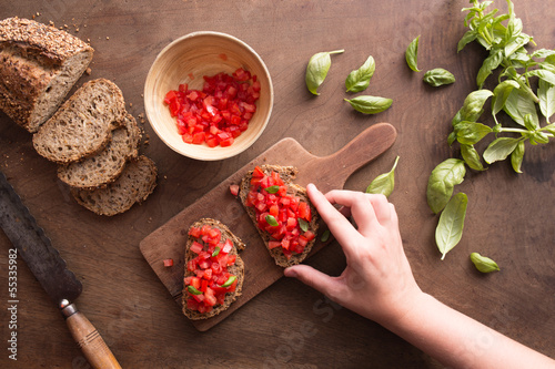 Photo: Hand holding Italian bruschetta Hand holding Italian bruschetta
