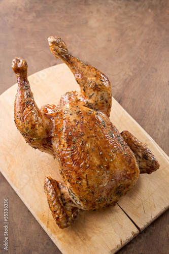 Photo: Whole roast chicken on wooden table Whole roast chicken on wooden table