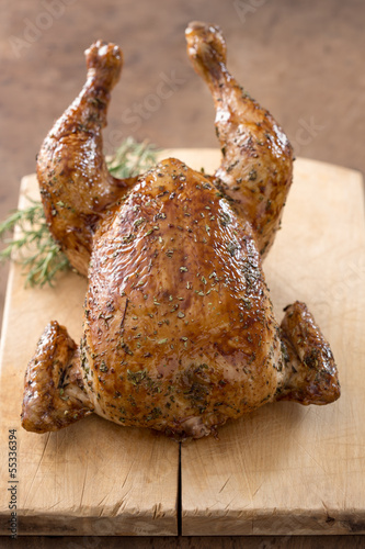 Photo: Whole roast chicken on wooden table Whole roast chicken on wooden table