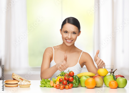 Photo: woman with fruits rejecting junk food woman with fruits rejecting junk food