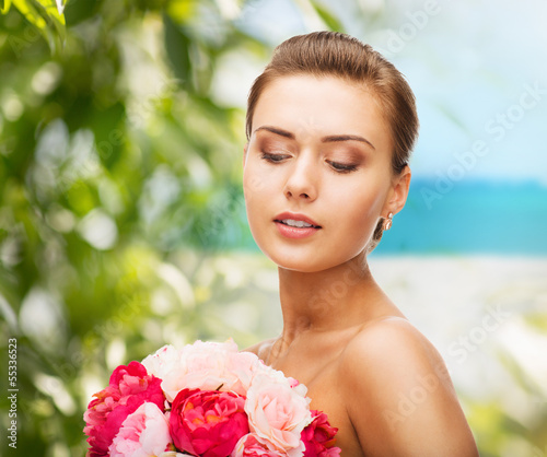 Photo: woman wearing earrings and holding flowers woman wearing earrings and holding flowers