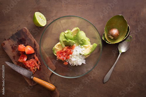 Photo: Preparing homemade guacamole on wooden table Preparing homemade guacamole on wooden table