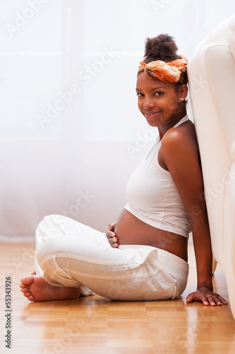 Photo: Young pregnant black woman touching her belly - African people Young pregnant black woman touching her belly - African people