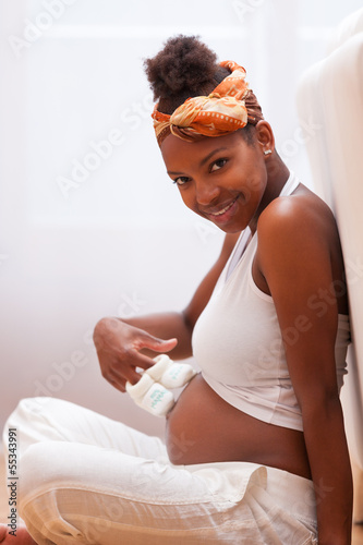 Photo: Young pregnant black woman touching her belly - African people Young pregnant black woman touching her belly - African people