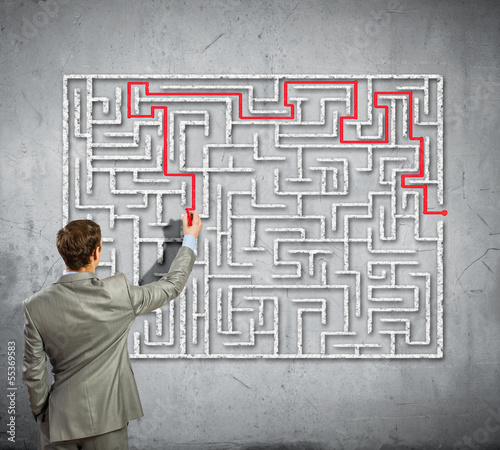 Photo: Businessman solving labyrinth problem Businessman solving labyrinth problem