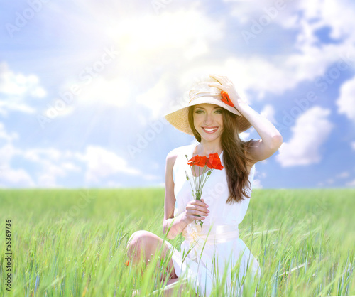 Photo: Portrait of beautiful young woman with poppies in the field Portrait of beautiful young woman with poppies in the field