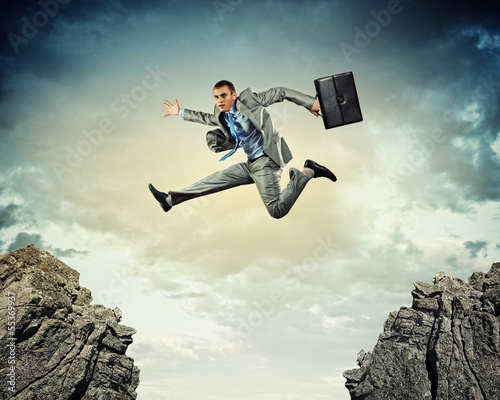 Photo: Businessman jumping over gap Businessman jumping over gap